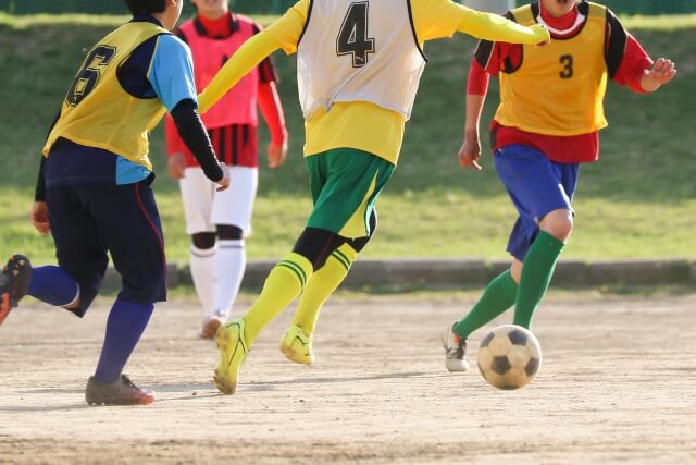サッカーをする成長期の高校生たち