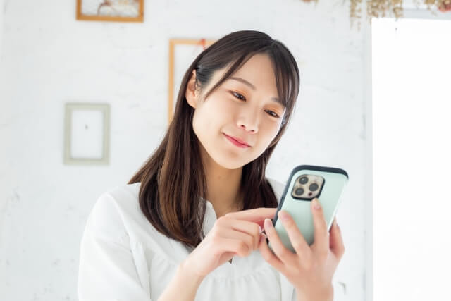スマホでオンライン診療を受ける笑顔の女性